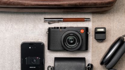 The Leica D-Lux 8 camera surrounded by other luxury goods