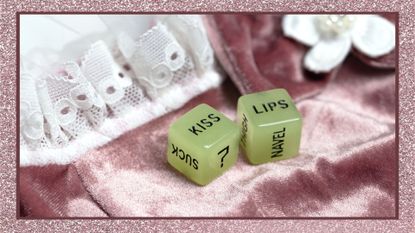 Two dice for erotic sexual game with the text kiss lips and neck on pink satin fabric background, Valentines Day, Love, Sex concept playful game couples, best sex games