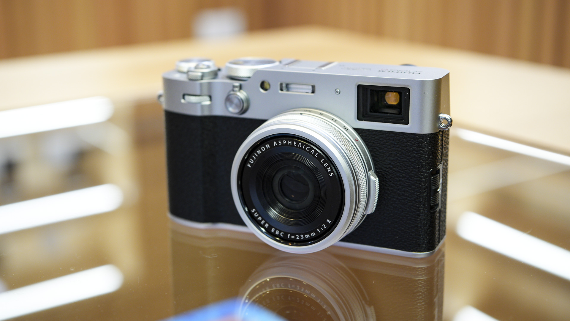 Front of the Fujifilm X100VI reflected in glass table
