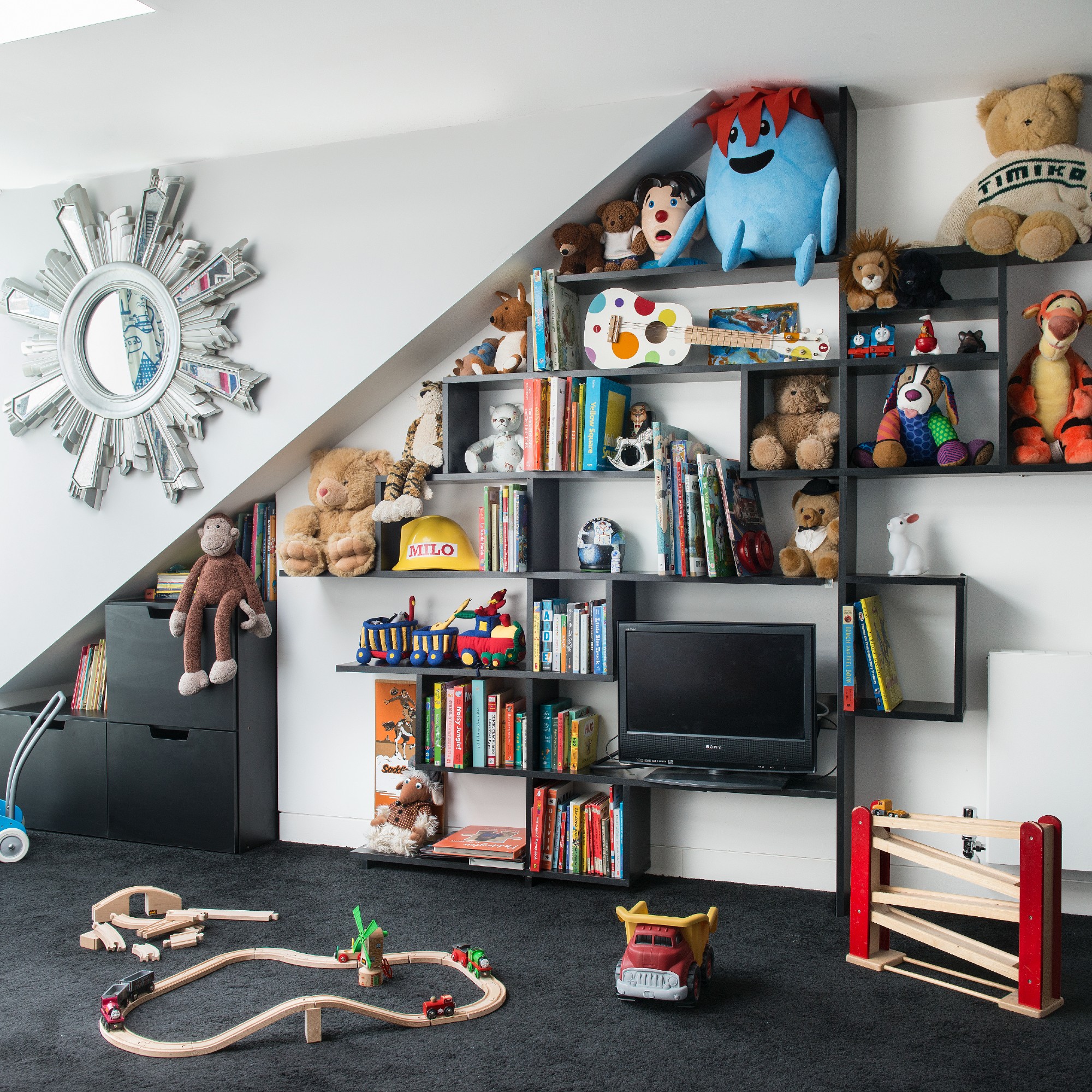 A slanted bookshelf filled with toys