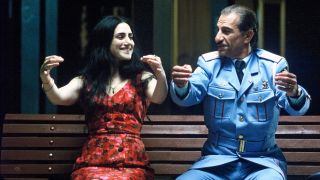 Ronit Elkabetz and Sasson Gabai on a bench tohether copying each other's movements in 2007 Israeli film, The Band's Visit