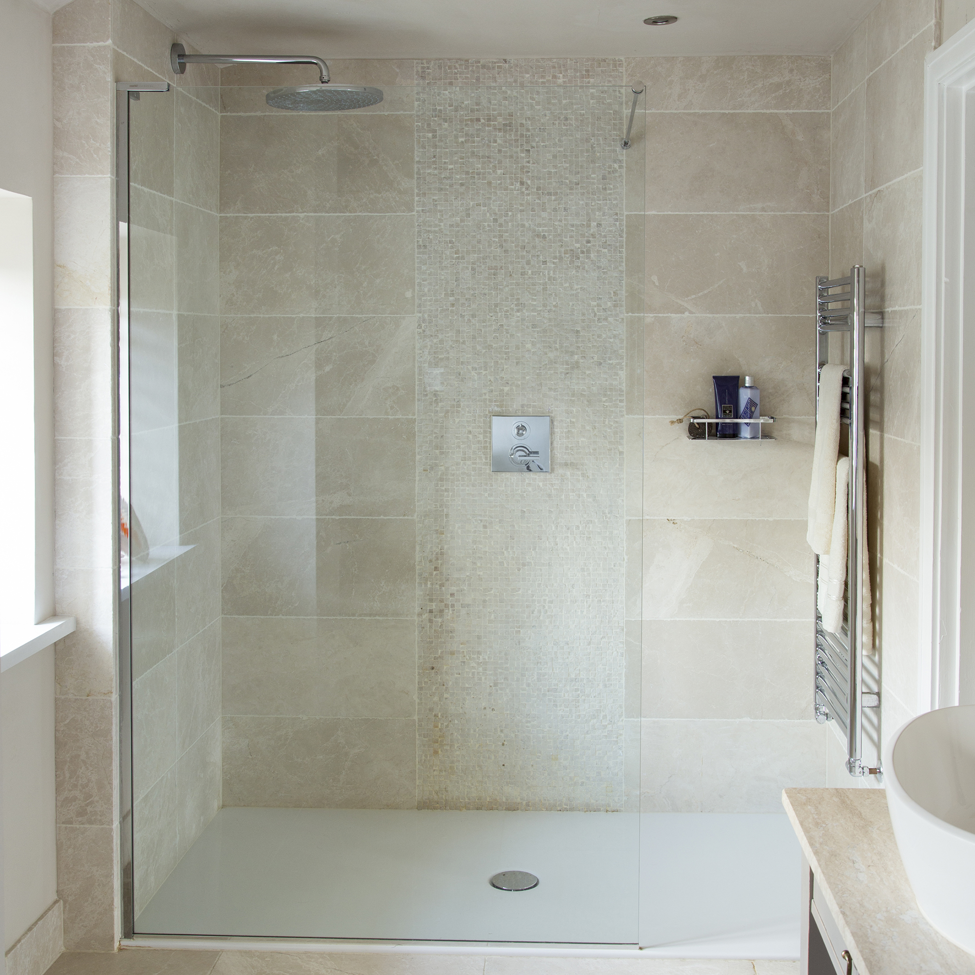 bathroom with tiled walls and shower on wall