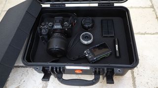 Vanguard Supreme 40F hard case filled with camera gear on a flagstone surface