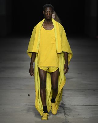 Model in yellow outfit and shoes walking on runway at Milan Fashion Week