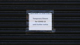 sign on a storefront reads "temporary closure for COVID-19, until further notice"
