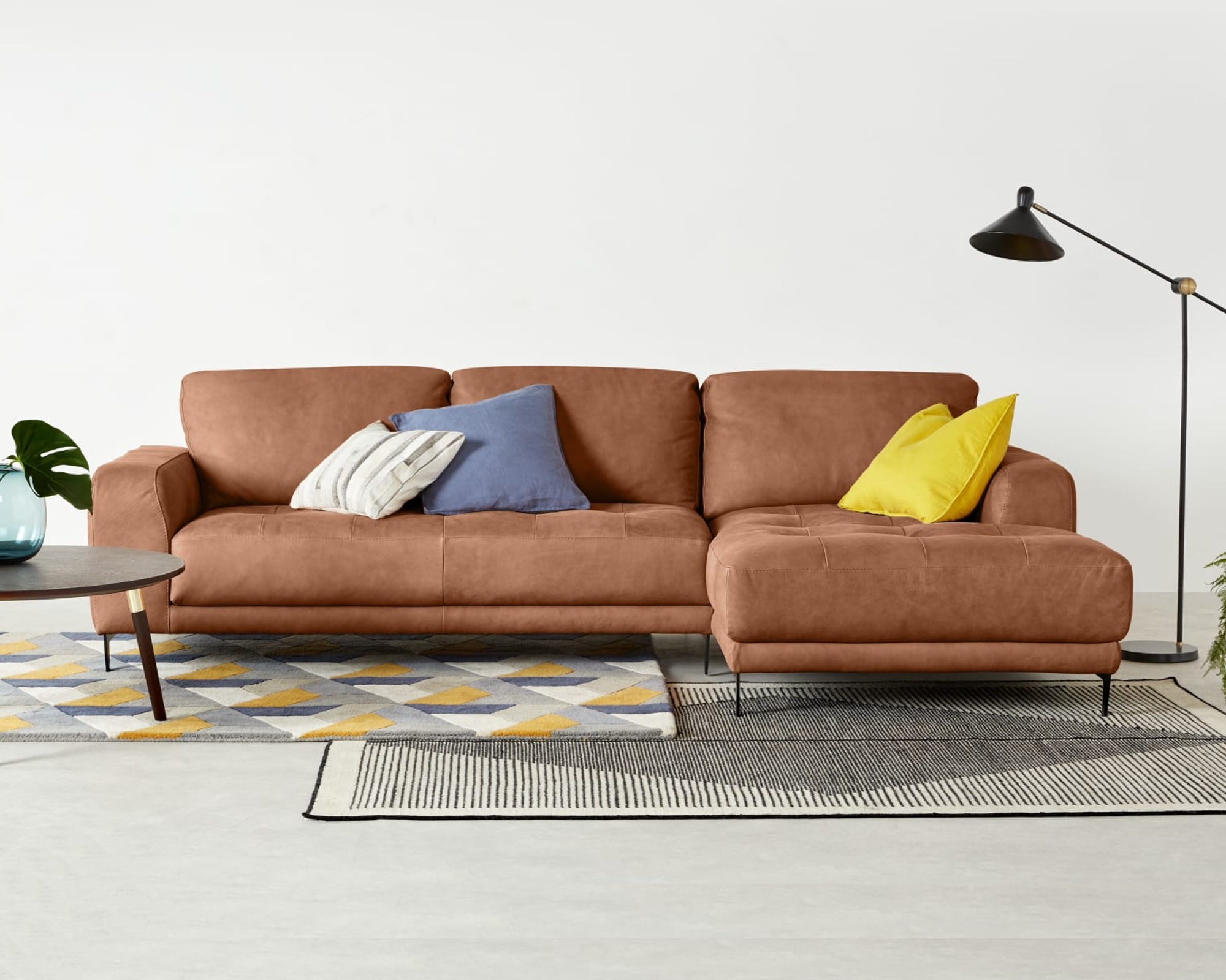 A tan leather sofa with chaise section in a modern living room