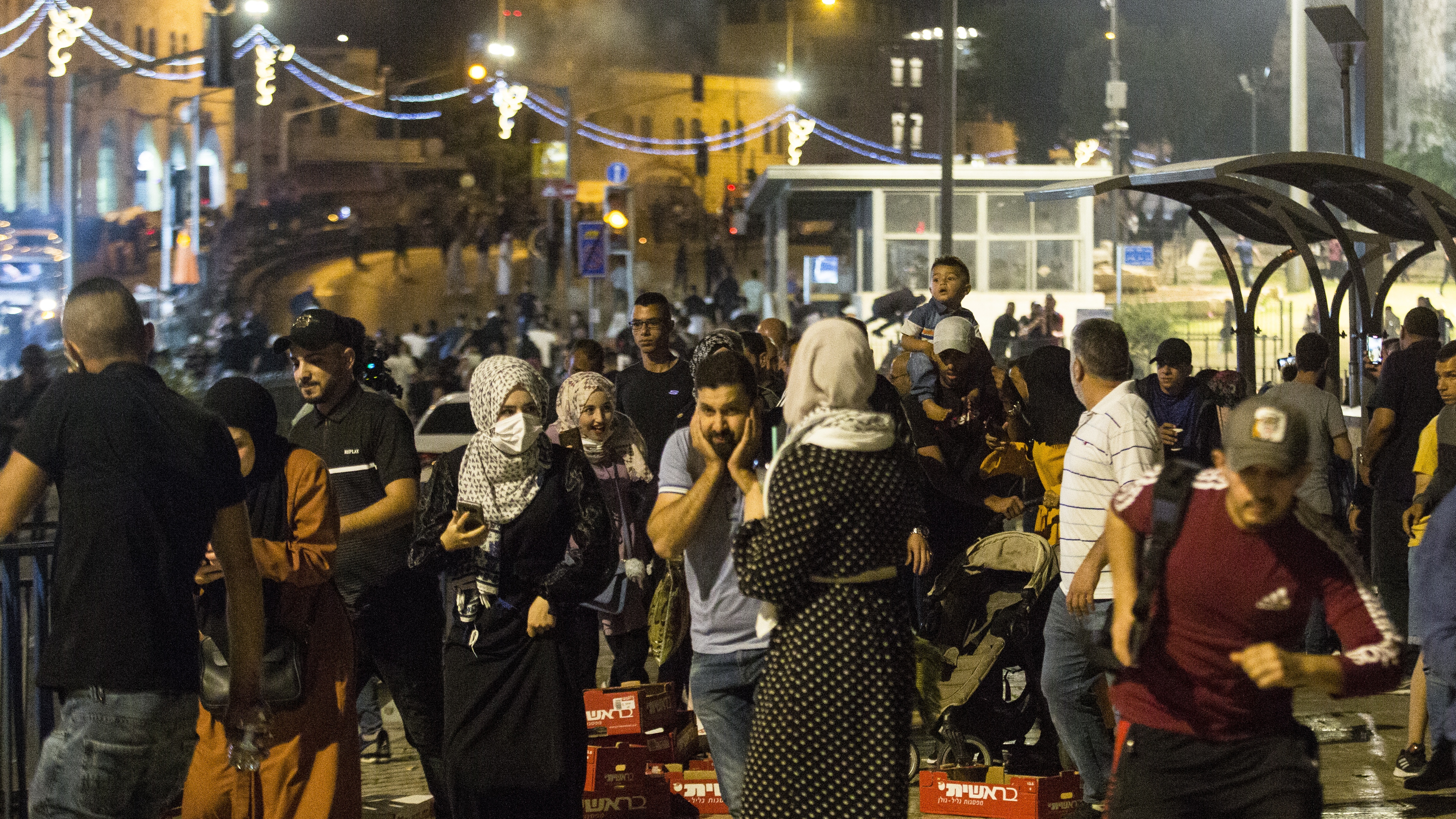 Palestinians flee from Israeli security forces near the Al-Aqsa mosque