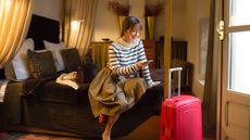 Woman in hotel room with suitcase