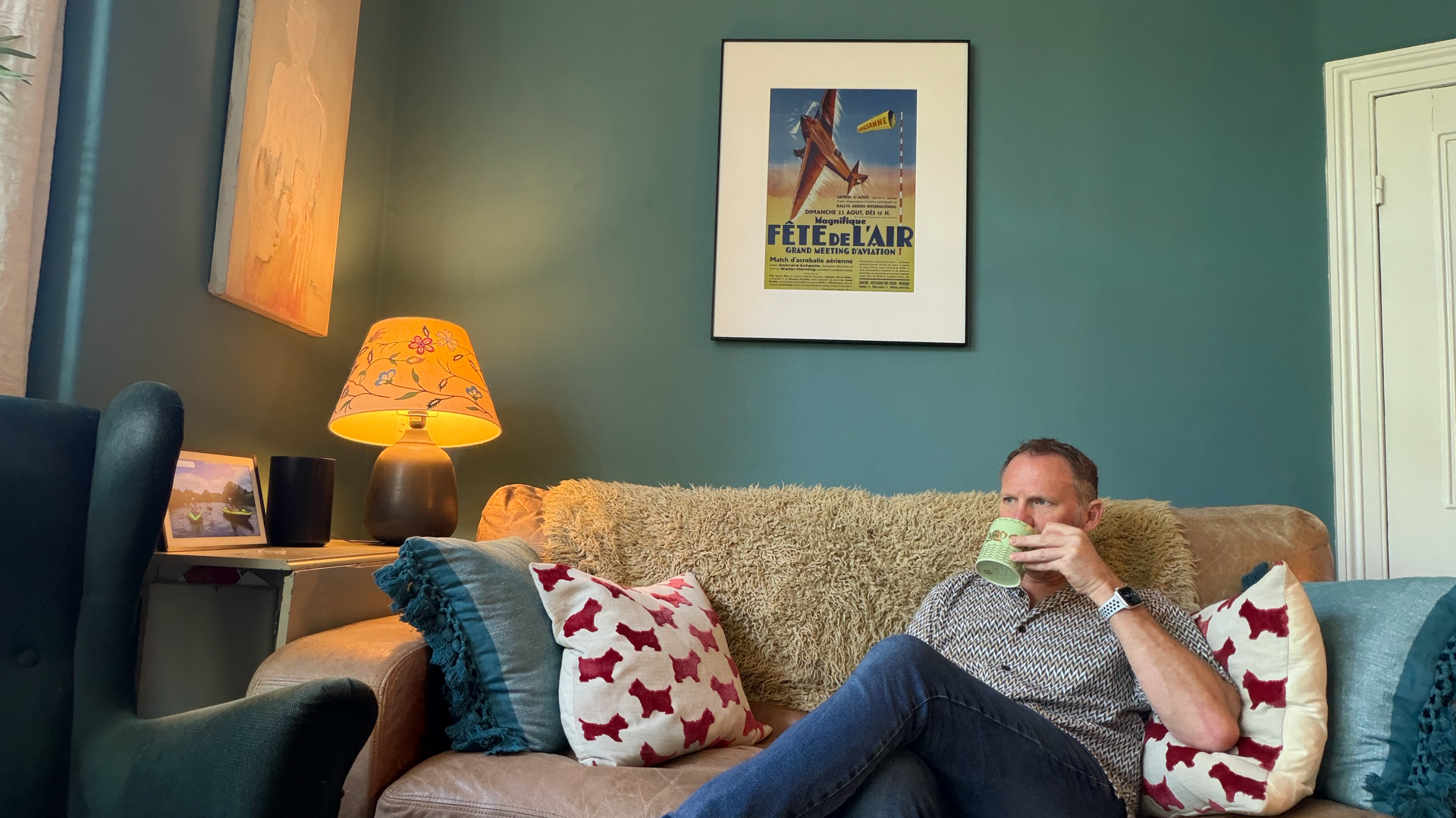 InkPoster Tela 28.5" frame showing poster in room with man drinking a cuppa