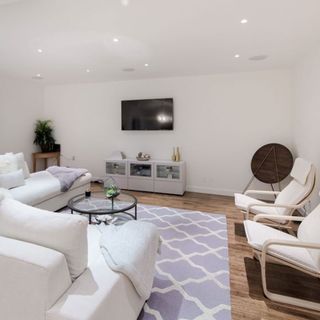 living room with tv on white wall and couch