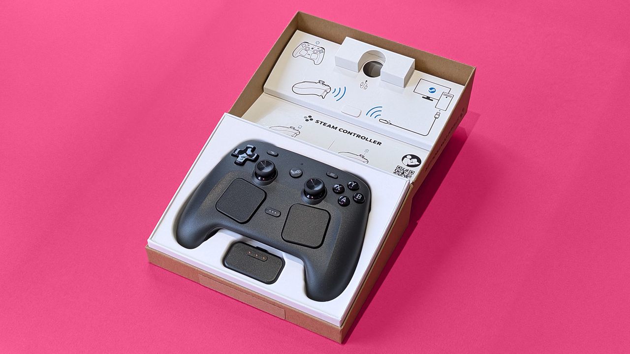 Valve Steam Controller (2026) in its open retail box against a magenta card background