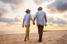 Older couple walking on the beach 