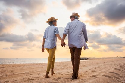 Older couple walking on the beach 
