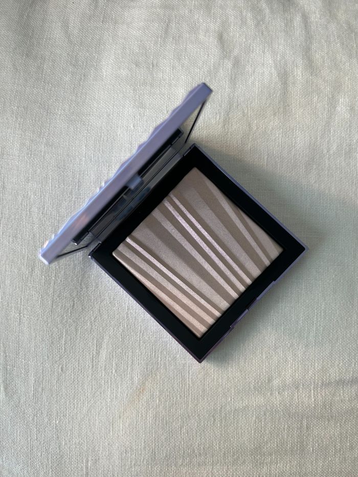 Nars Aura Illuminating Face &amp;amp; Body Powder on a white linen background