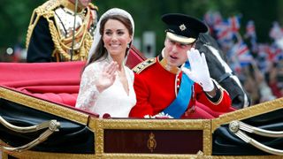 Catherine, Duchess of Cambridge and Prince William, Duke of Cambridge, wearing his red tunic uniform of the Irish Guards, travel down The Mall in a carriage after getting married in 2011