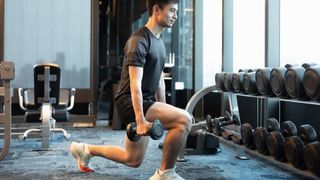 Man doing lunges while holding dumbbells