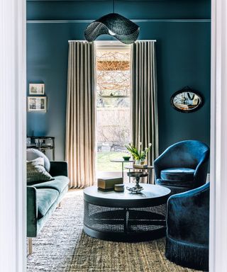 living room with blue walls, dark blue chairs and blue sofa