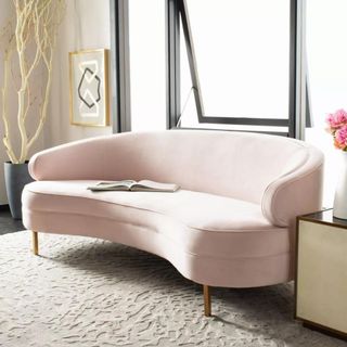 Pink curved sofa with magazine on