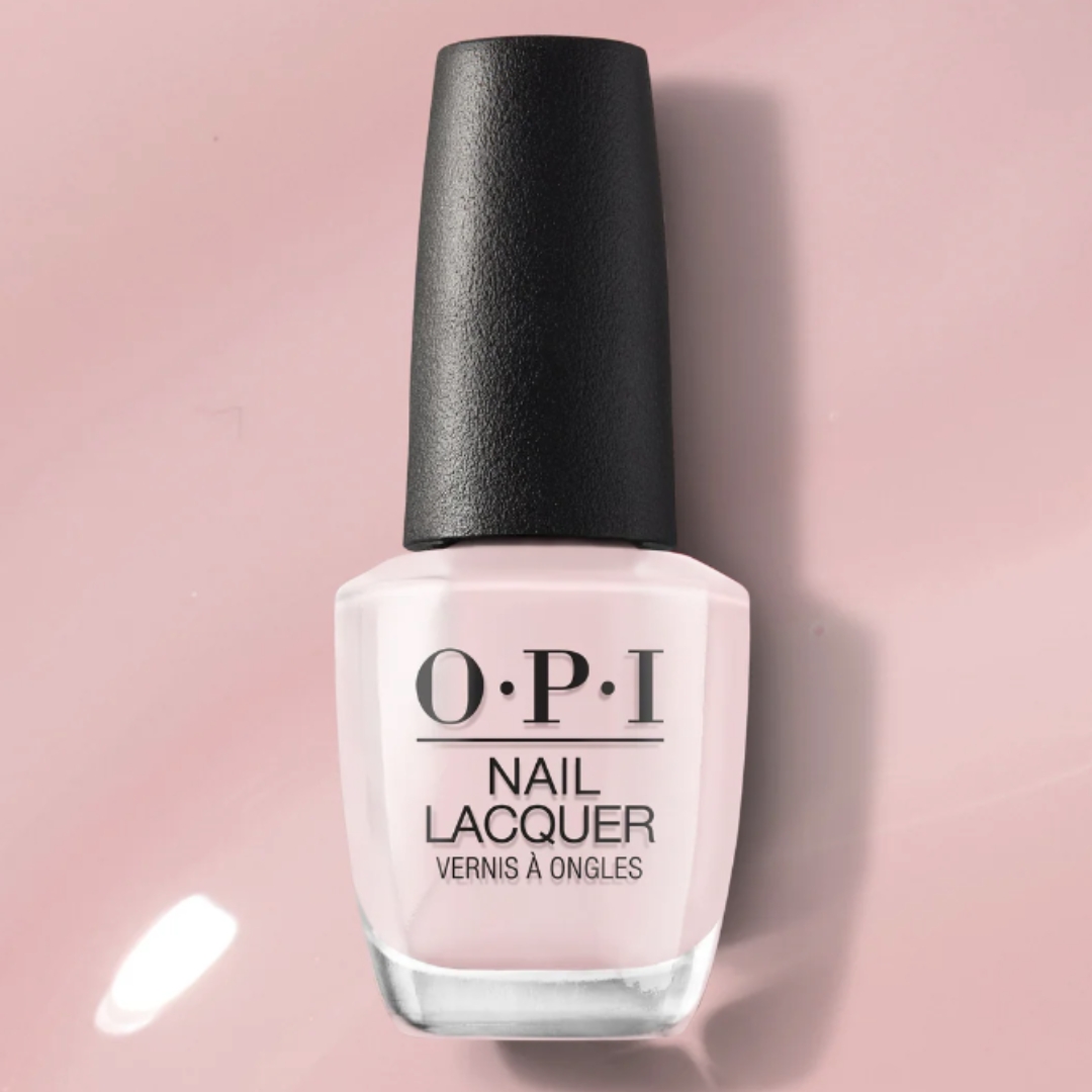 A product shot of the OPI Baby, Take a Vow Nail Polish, pictured on a pink polish background (to demonstrate the nail lacquer's colour)