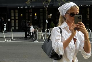 a woman wearing a white shirt and black handbag