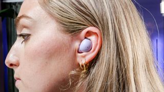 Galaxy Buds Pro 2 in purple placed in hands-on reviewer, Kate Kozuch, ear.