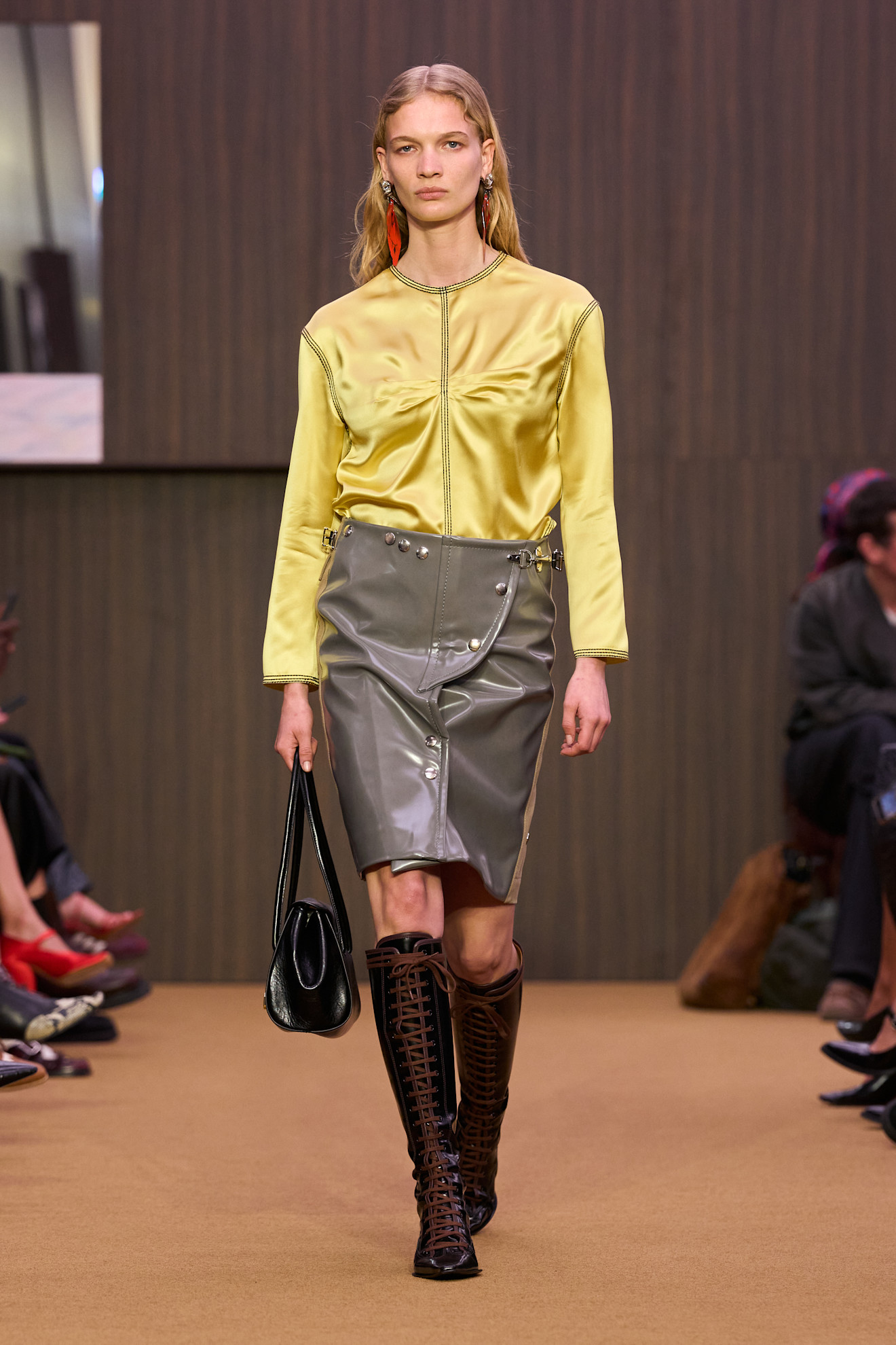 Model wears lace-up knee-high boots on the A/W26 runway