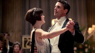 Michelle Dockery and Matthew Goode dance together finely dressed in Downton Abbey: The Movie.