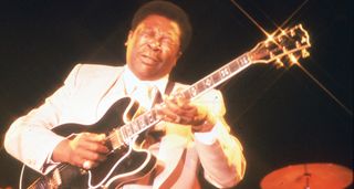 B.B. King wears a white suit and bends a note on his Gibson ES-355