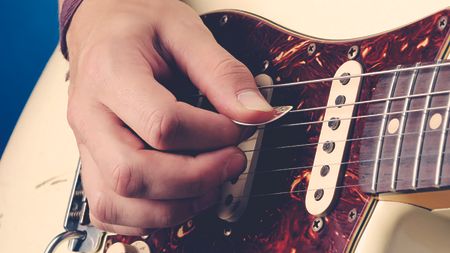 Player holding a guitar pick