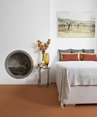 Bedroom carpet ideas with dark rust orange carpet, white walls and circular fireplace
