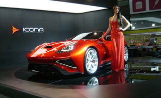 Red Icona Vulcano car on display at a car show with a model in a red dress