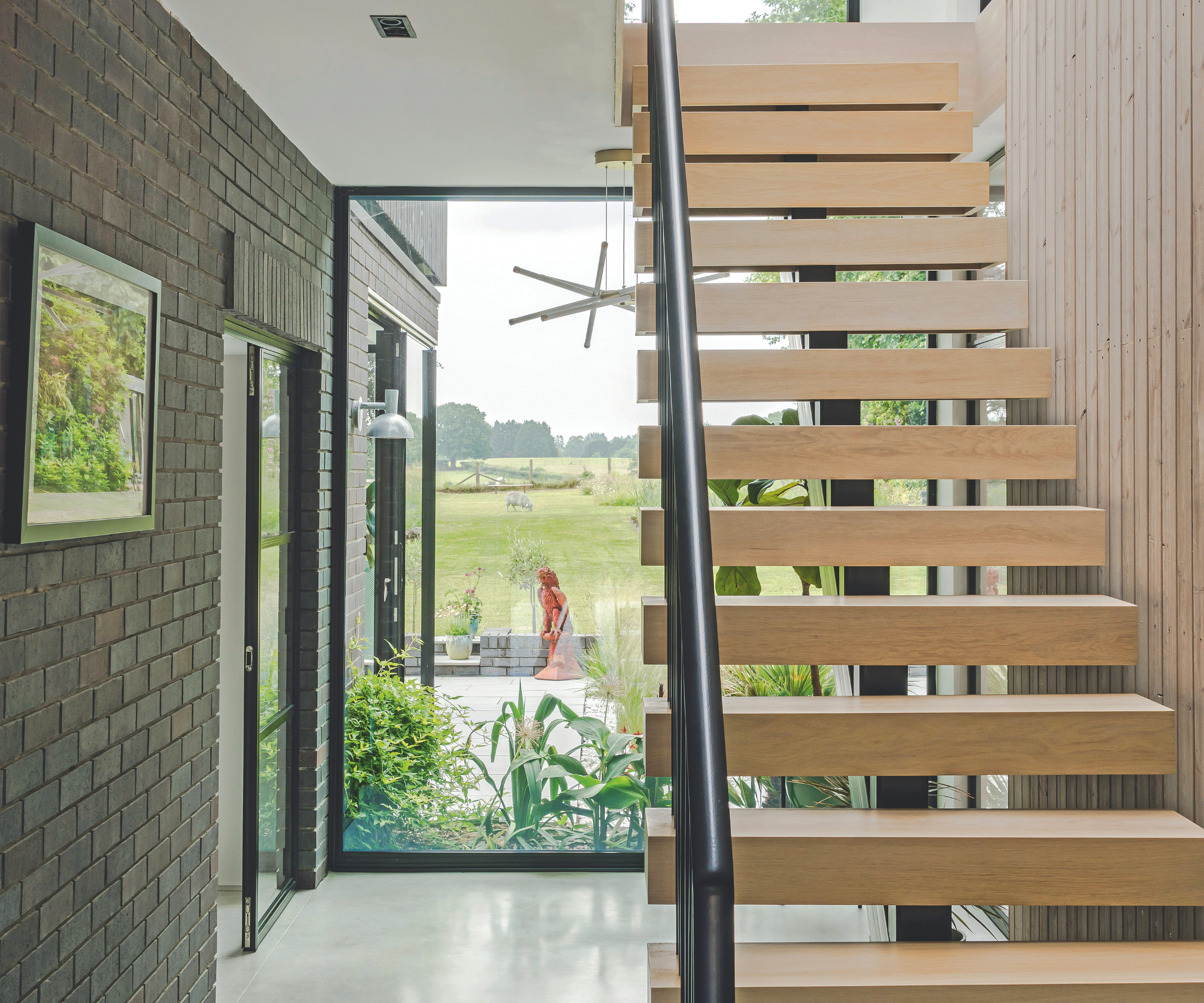 Ghost staircase with a floor to ceiling window behind it with views onto the patio and garden