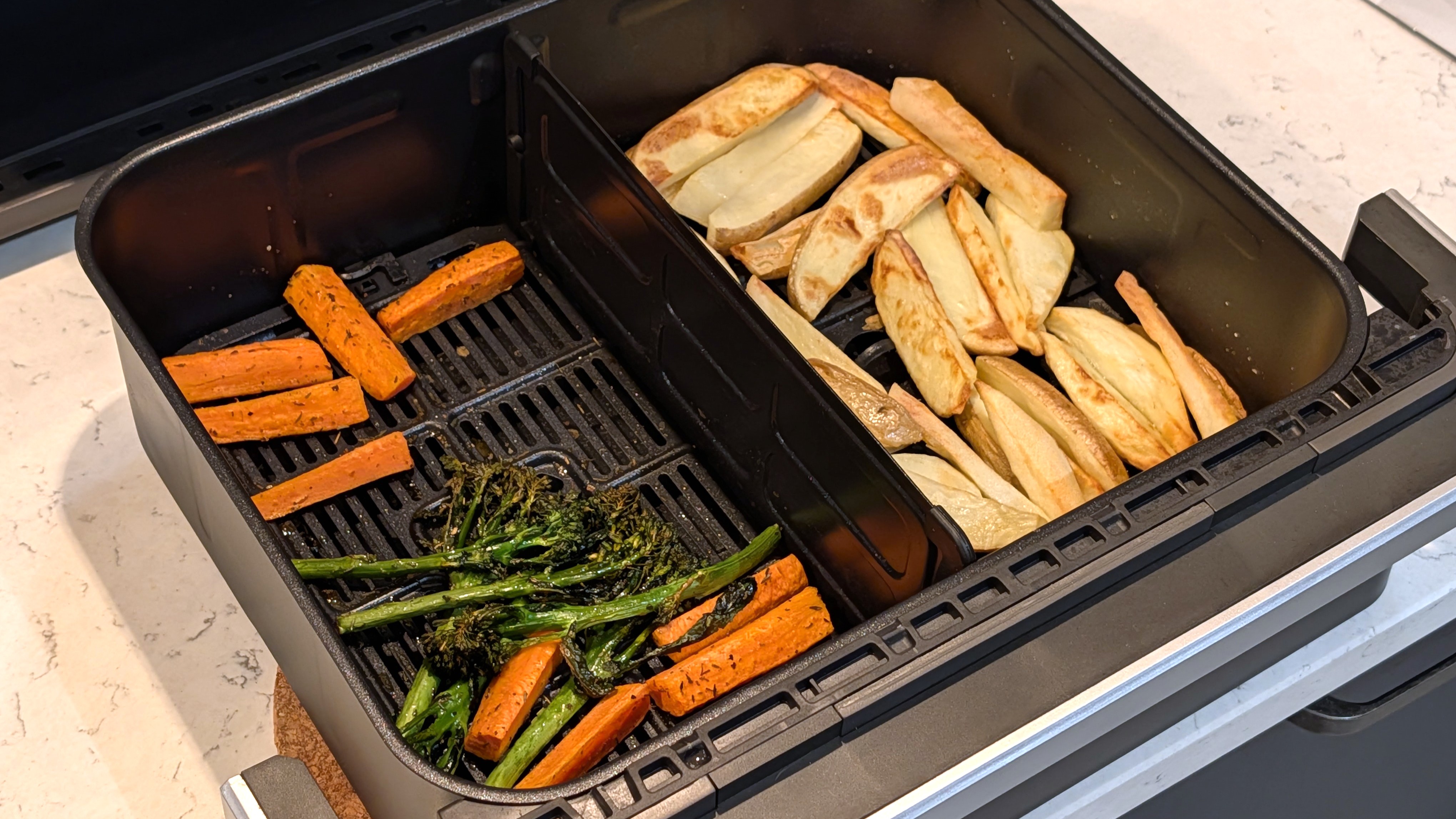 Cooked vegetables and fries in air fryer drawer