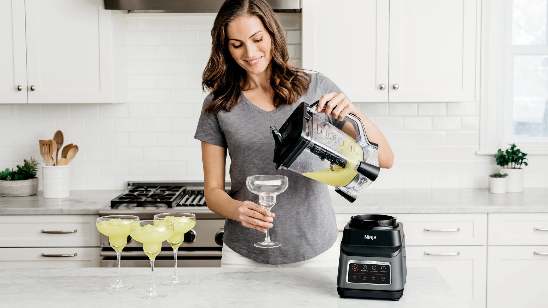 A woman pouring frozen cocktails from the Ninja Professional Plus blender