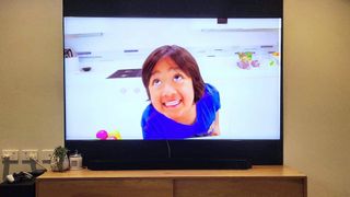 En video afspilles på et Samsung QN900B Neo QLED 8K TV, der står på et tv-bord af træ