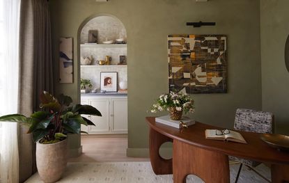 A study room with wooden furniture and earthy green walls