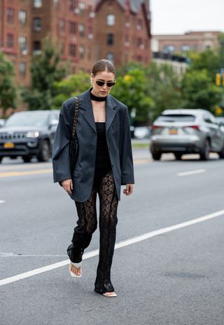 : Annabel Rosendahl wearing grey oversized striped blazer, laced black pants outside Ulla Johnson on September 11, 2022 in New York City