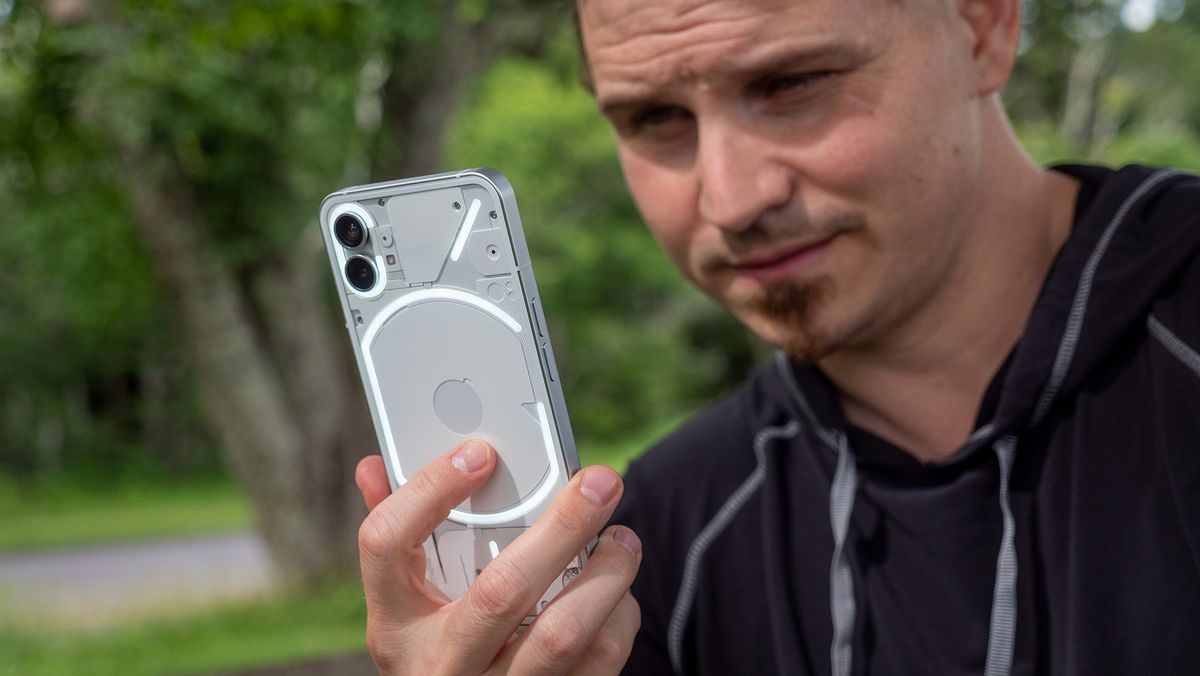 Holding the Nothing Phone (1) with its glyph lights illuminated