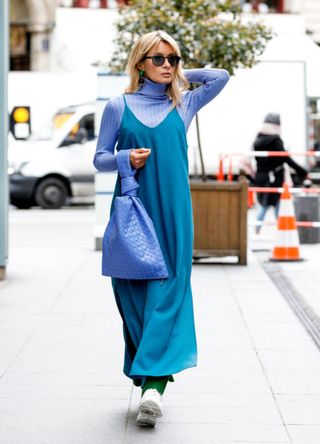 Gitta Banko in an all-blue outfit comprised of a blue dress, turtleneck and bag