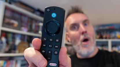 Amazon Fire TV Stick remote held by Rik Henderson in a home setting