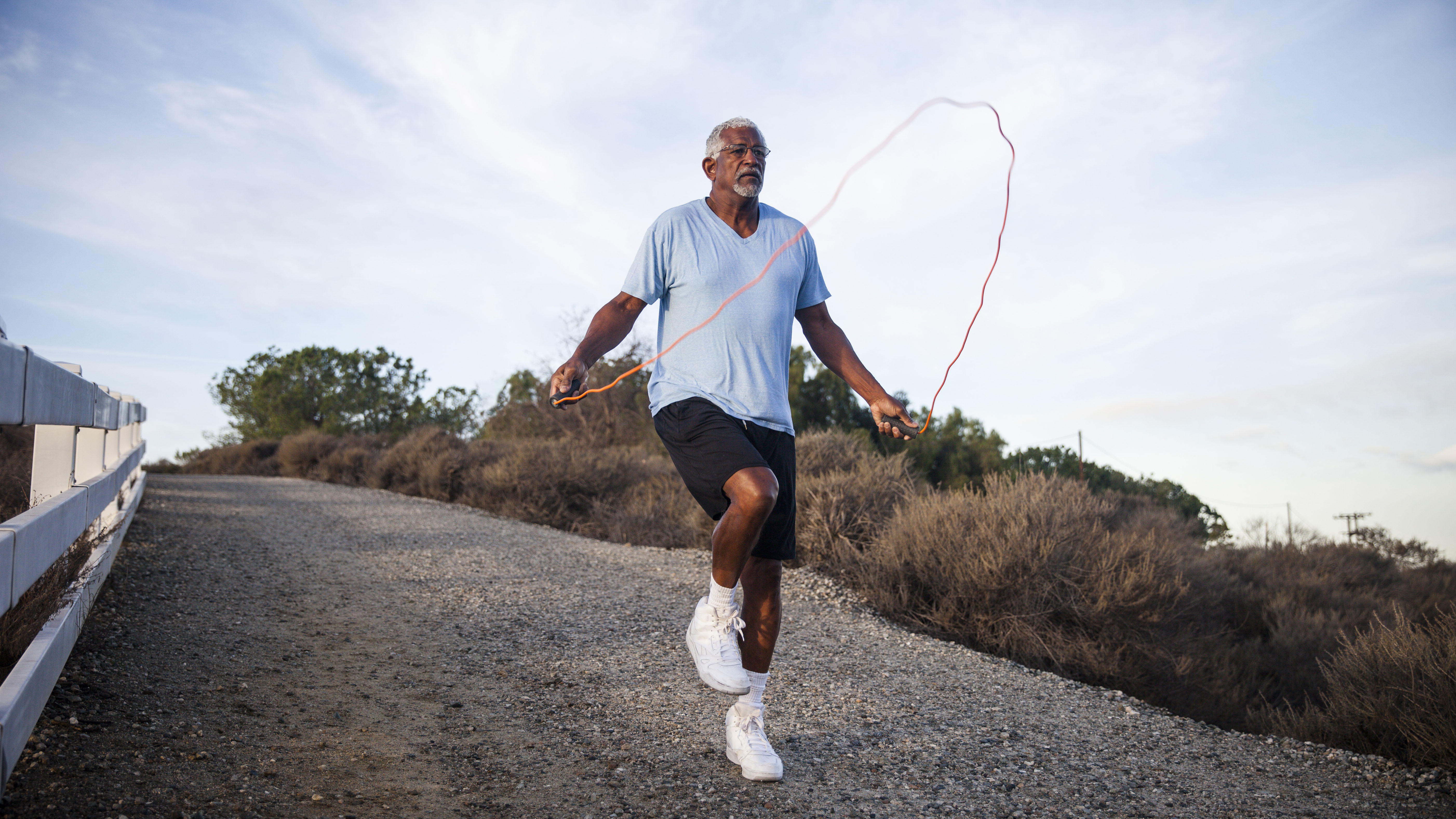 Hombre saltando la cuerda como ejercicio de entrenamiento cruzado al aire libre