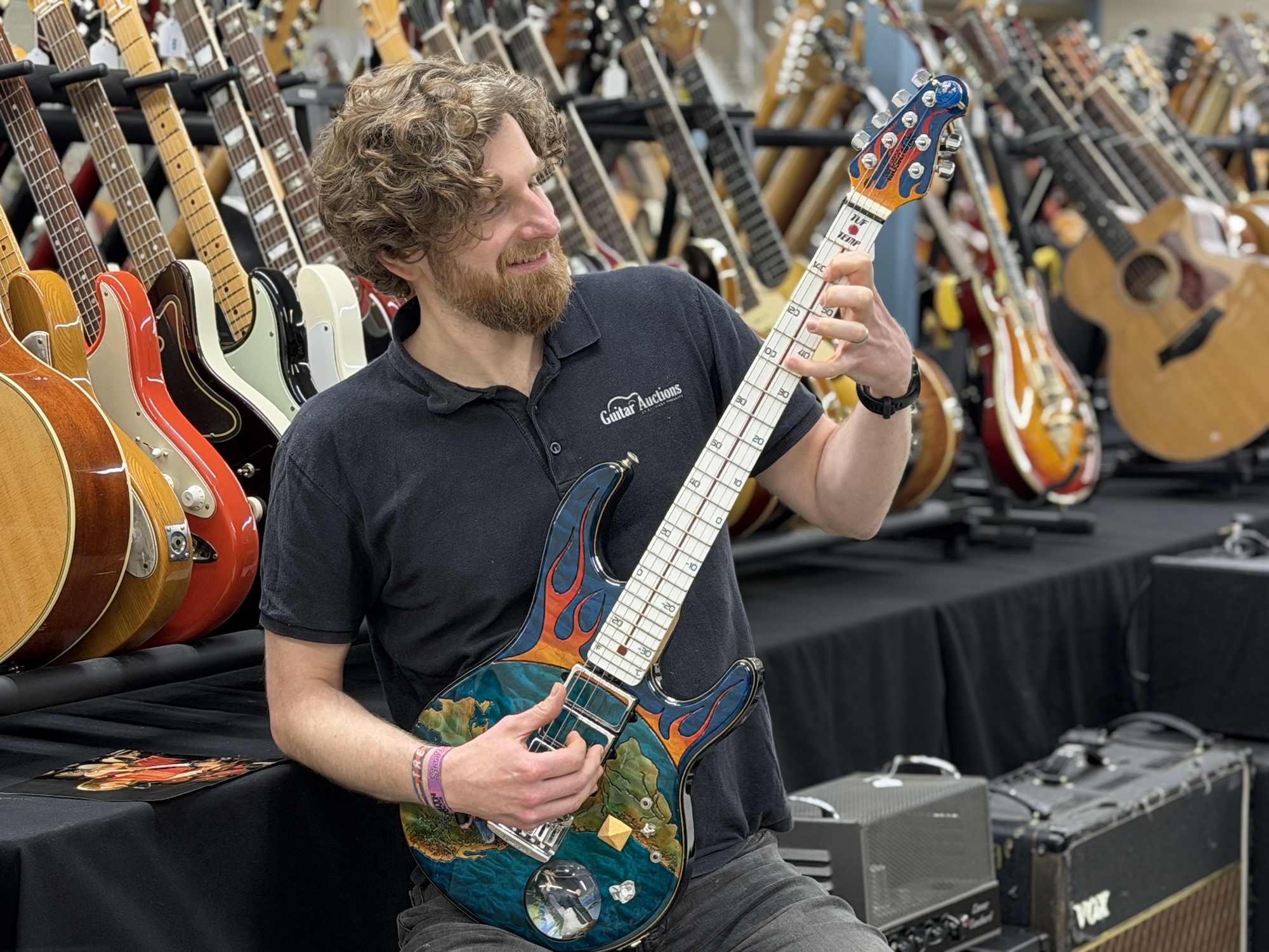 Auctioneer Luke Hobbs holds the Spinal Tap &amp;ldquo;World on Fire&amp;rdquo; guitar