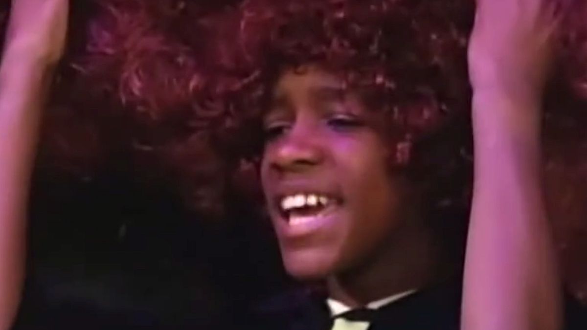 Screenshot of Bryan Hearne in red afro from Harry Bladder sketch in All That