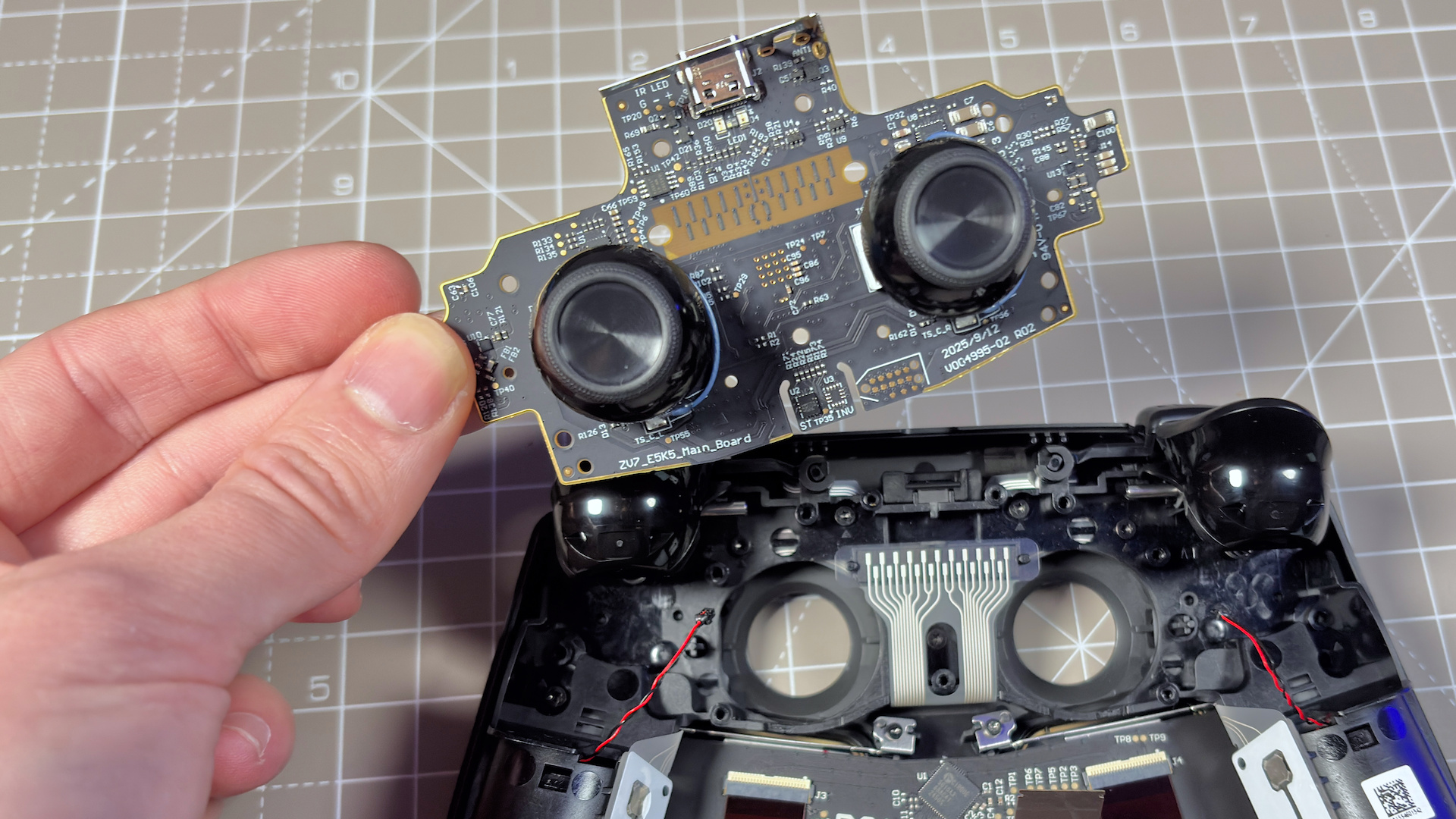 The Steam Controller on a desk during a teardown, with various parts removed.
