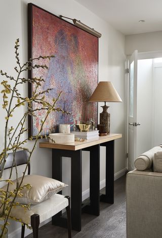entryway with narrow console table and large red art on the walls