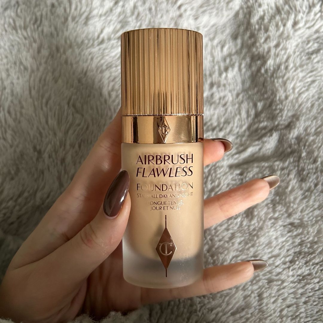 Image of Charlotte Tilbury Airbrush Flawless Foundation in hand with brown nails