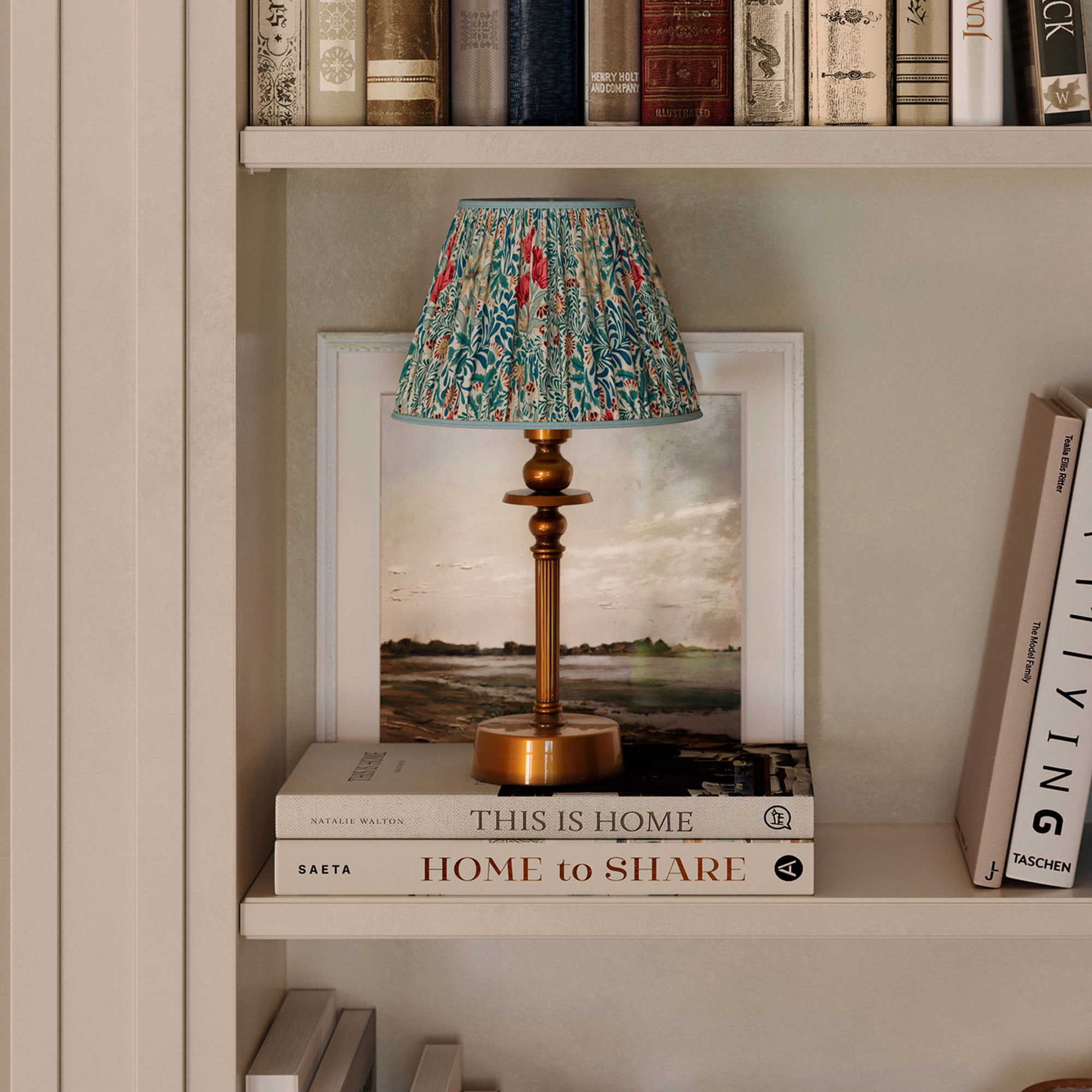 Grey shelves with books, and a copper base lamp with a patterned fabric lampshade