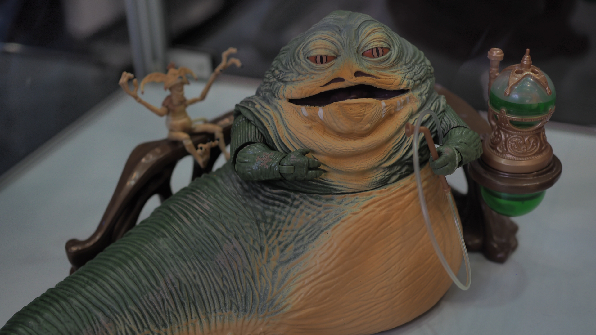 An action figure of Jabba sits on a plain surface