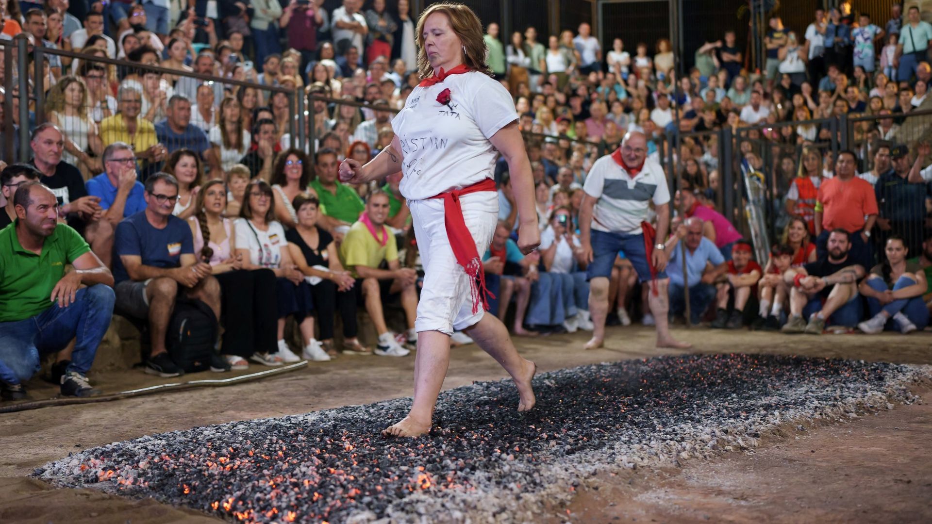 
                                A reveller walks on burning embers during the San Juan festival in San Pedro Manrique, Spain
                            