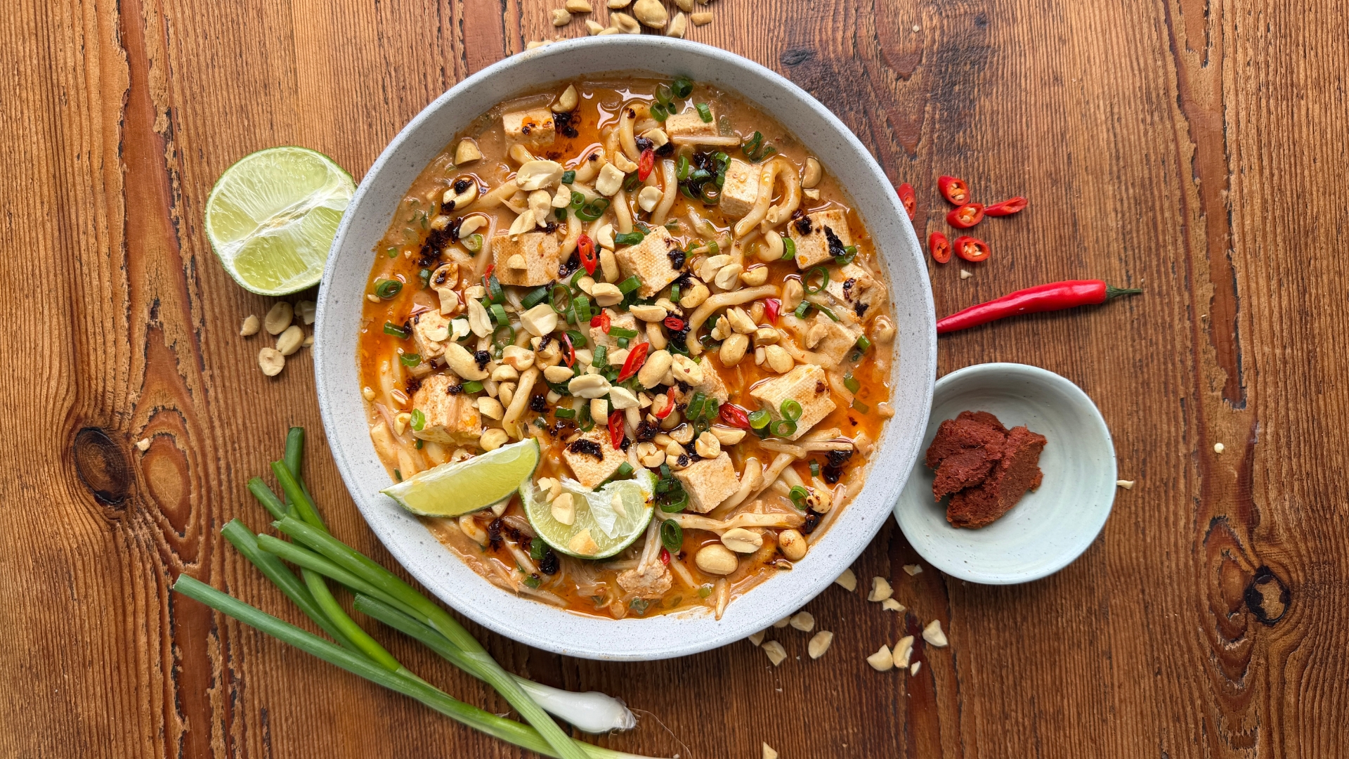 Satay Oodon Noodle Soup in a bowl on a wooden surface
